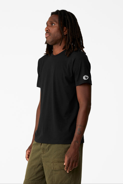 Man wearing a black t-shirt with a white logo on a white background